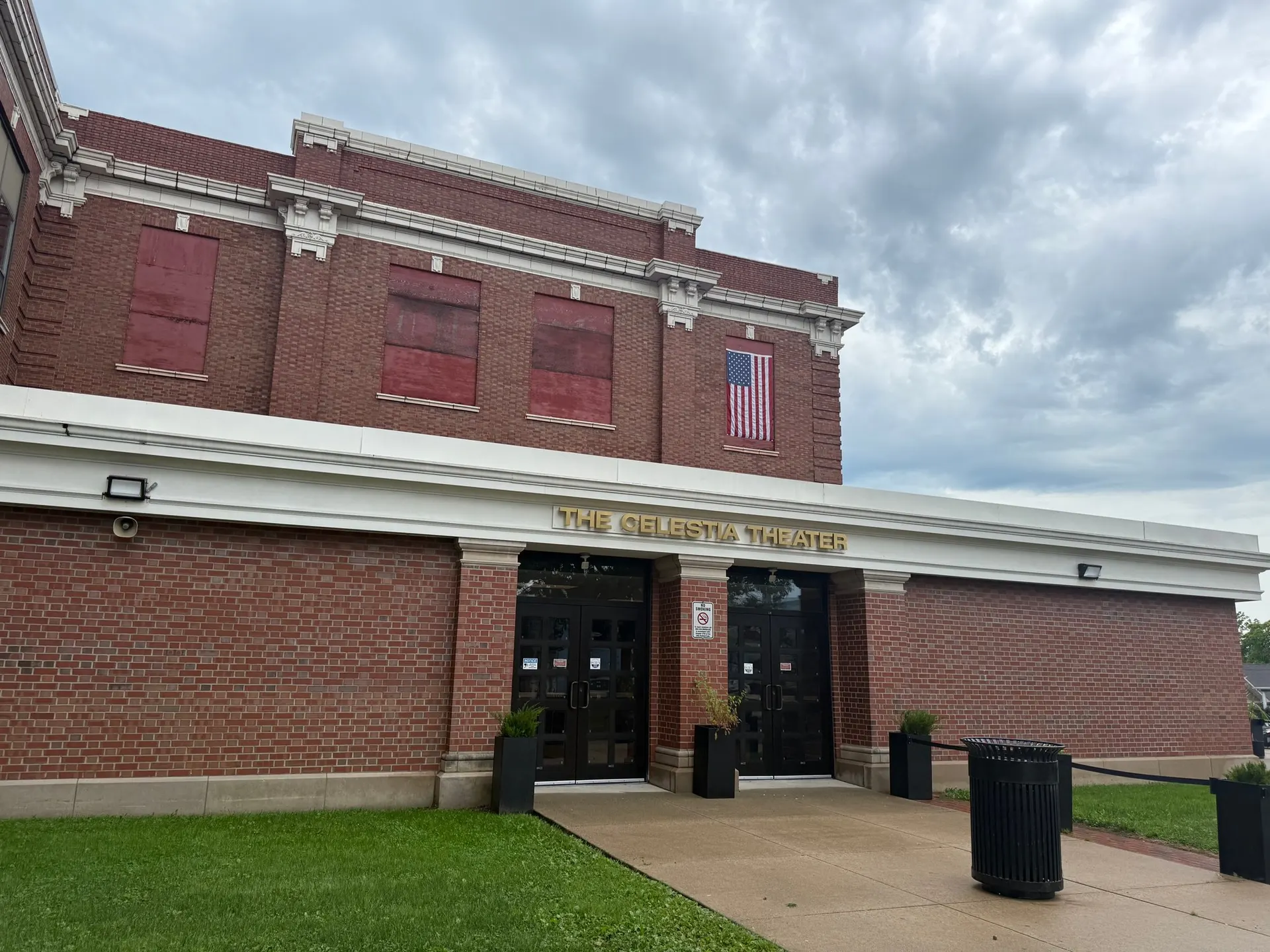 The Celestia Theater entrance on the side of the school under a stormy sky, flag flying above