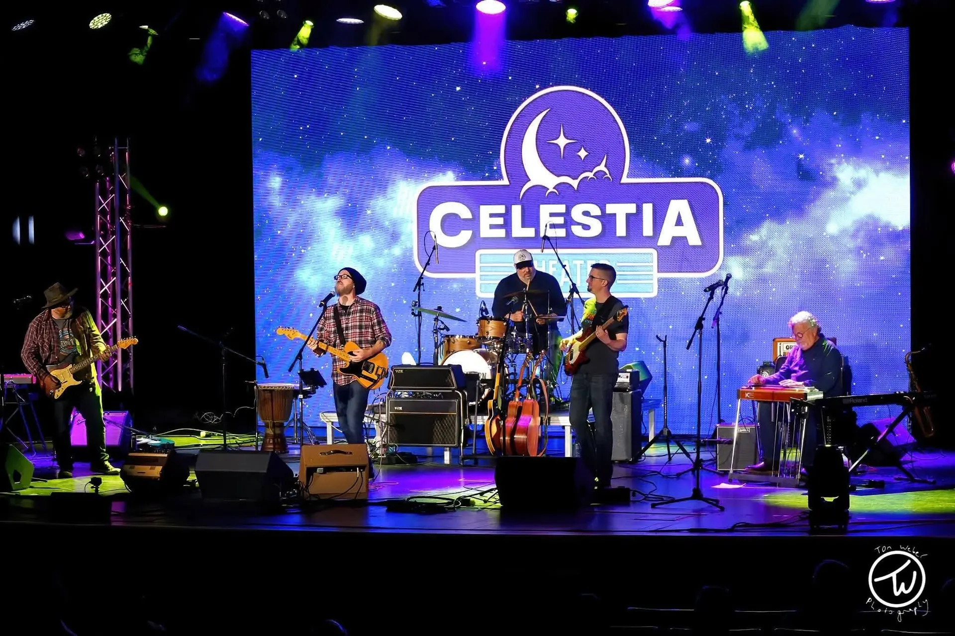 A five-piece band on the Celestia Theater stage in front of the LED wall showing the Celestia logo over a starry sky