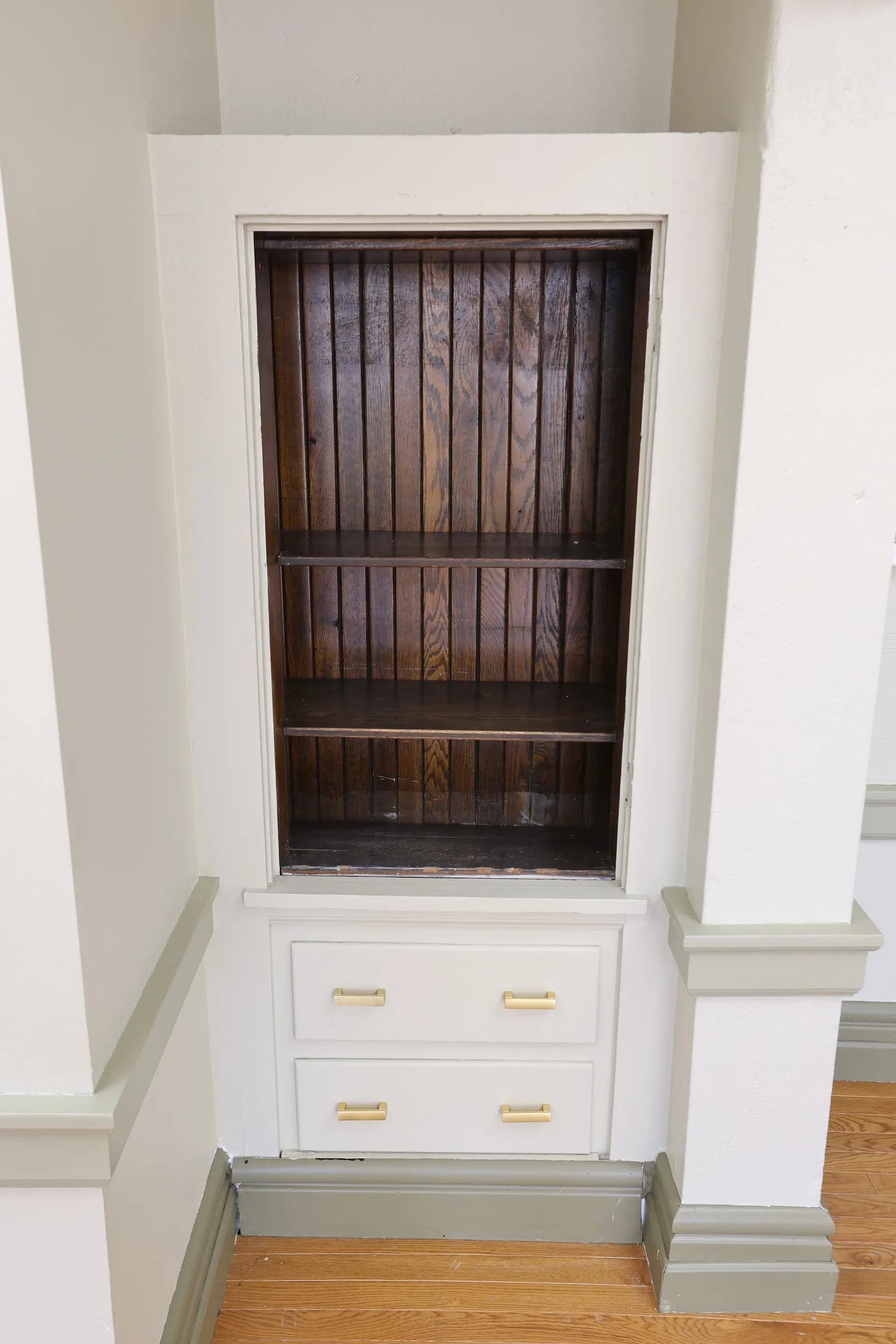 An original built-in oak cabinet, its wood grain restored