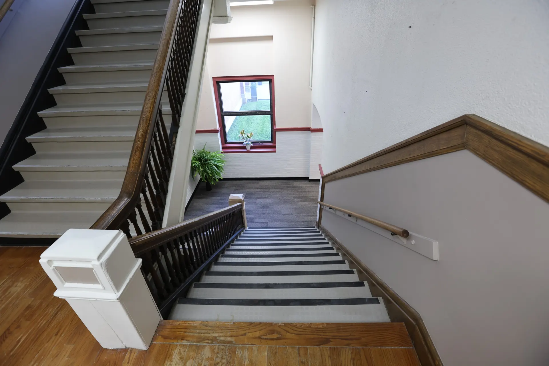 The main stairwell with its original oak banister and a window on the landing