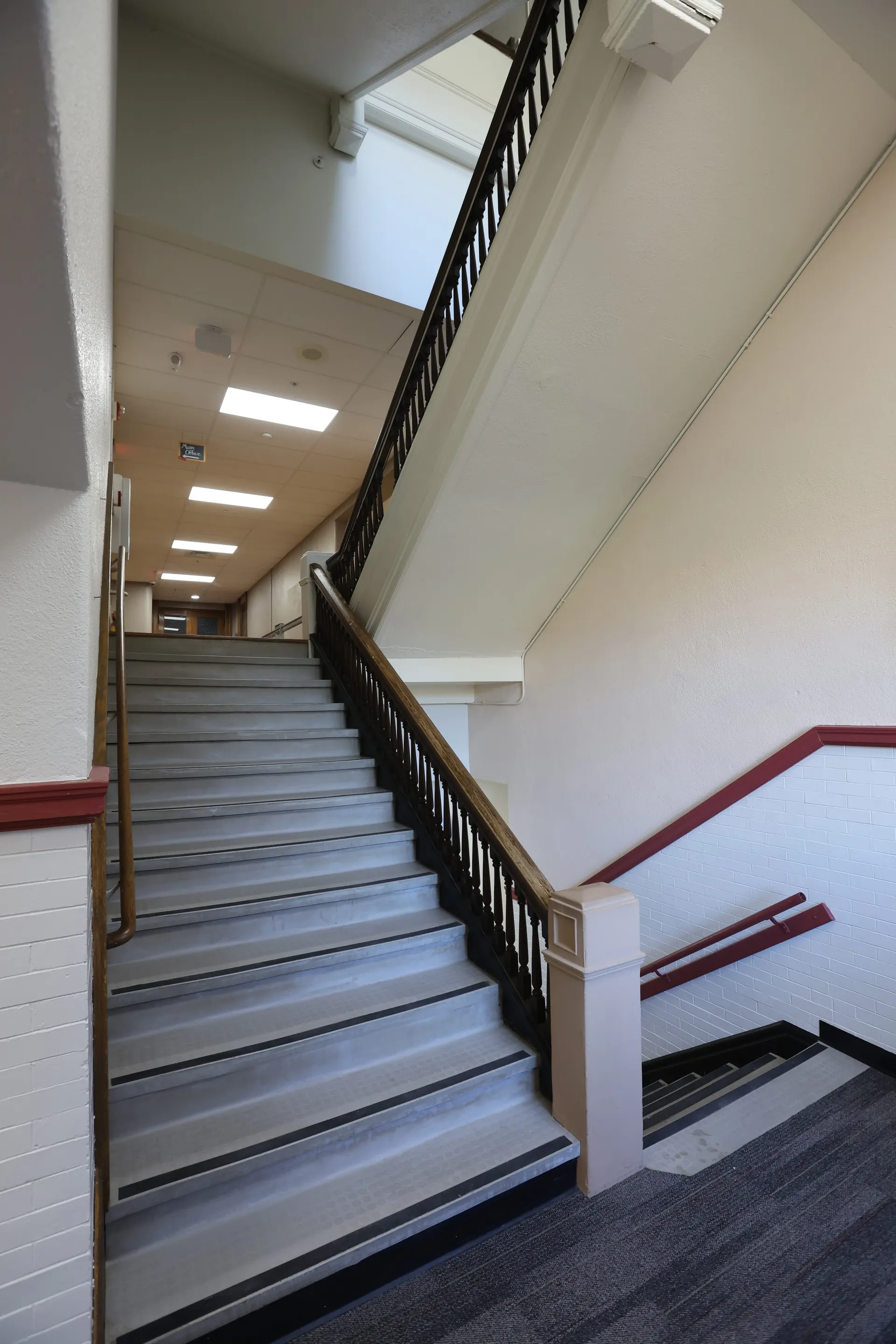 The main stairwell, oak banister and painted brick, climbing toward the upper floors