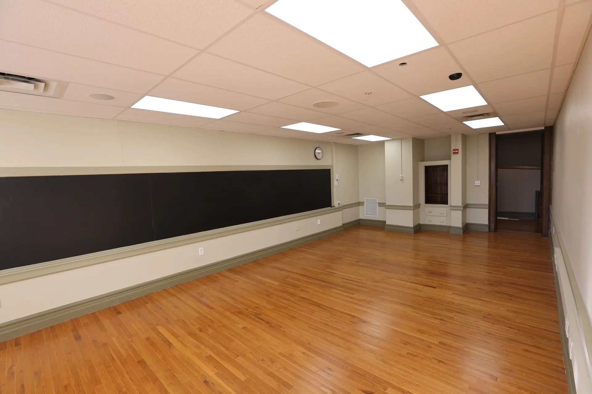 A suite with a long chalkboard, built-in cabinets and refinished hardwood